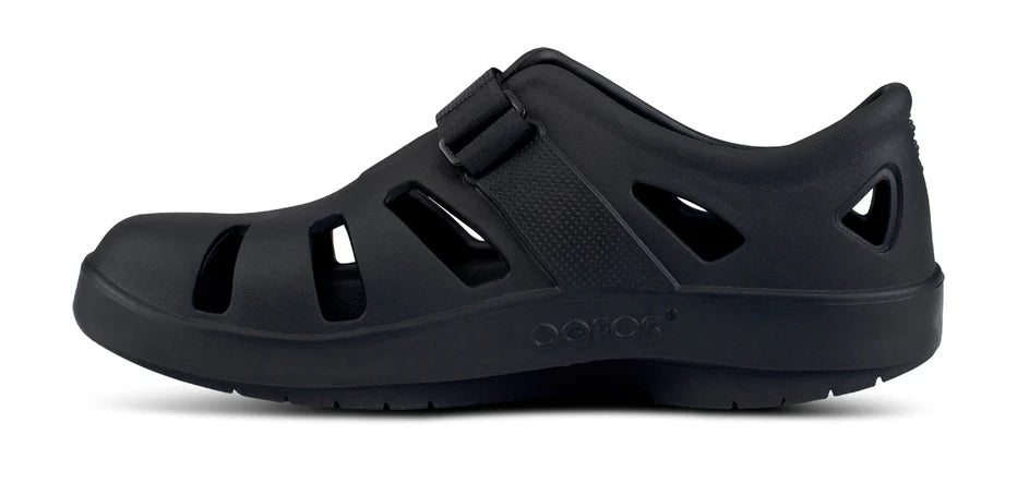 Oofos Oocandoo Sandal. Black. Medial view.