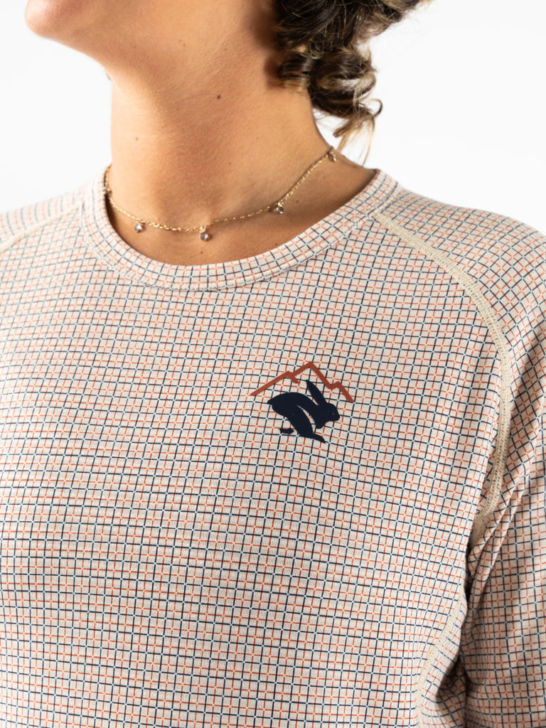 Women's rabbit layer one trail long sleeve. Light tan/plaid. Front view.