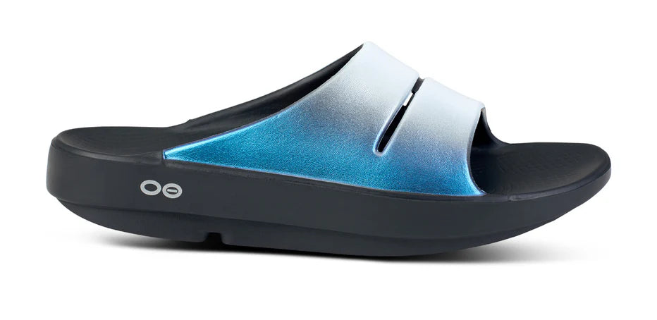 Women's Oofos Ooahh Luxe Slide. Light Blue upper. Black midsole. Lateral view.